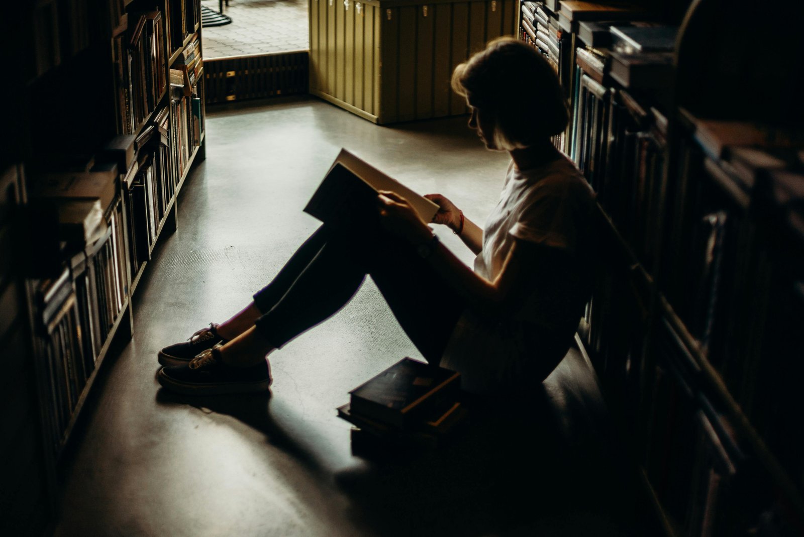 Jeune femme étudiant dans une bibliothèque modeste